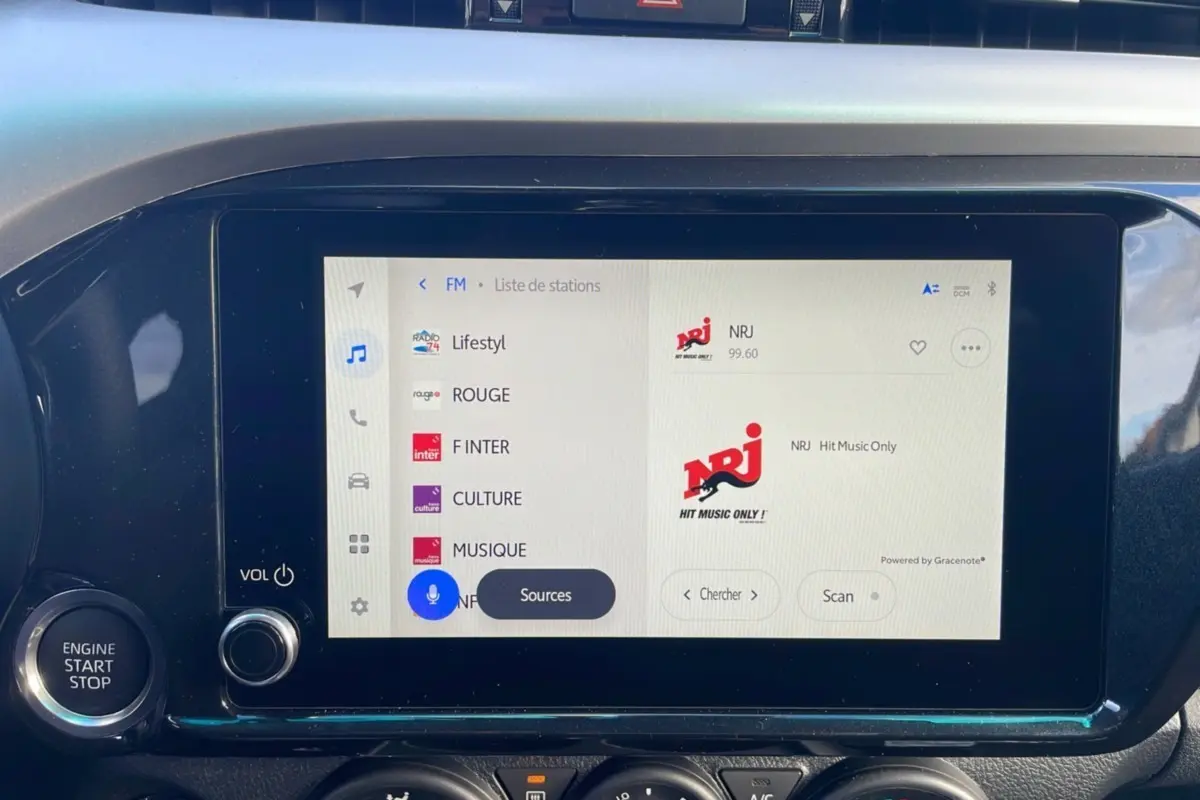 Écran tactile central du Toyota Hilux 2025 blanc, affichant la liste des stations radio FM avec NRJ sélectionné.