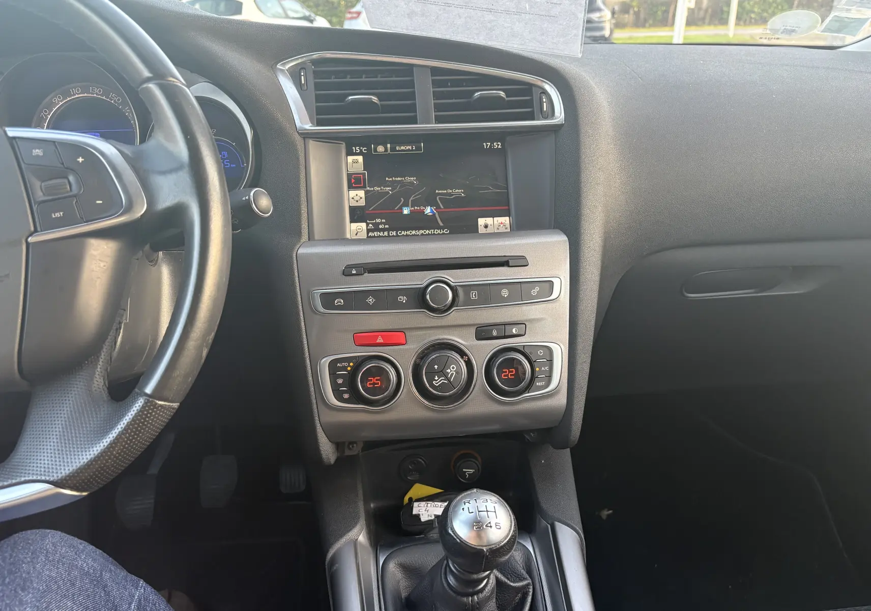 Intérieur de la Citroën C4 II 2.0 HDI 150 HYB 2015, vue centrale sur tableau de bord avec écran GPS et levier de vitesses manuel.