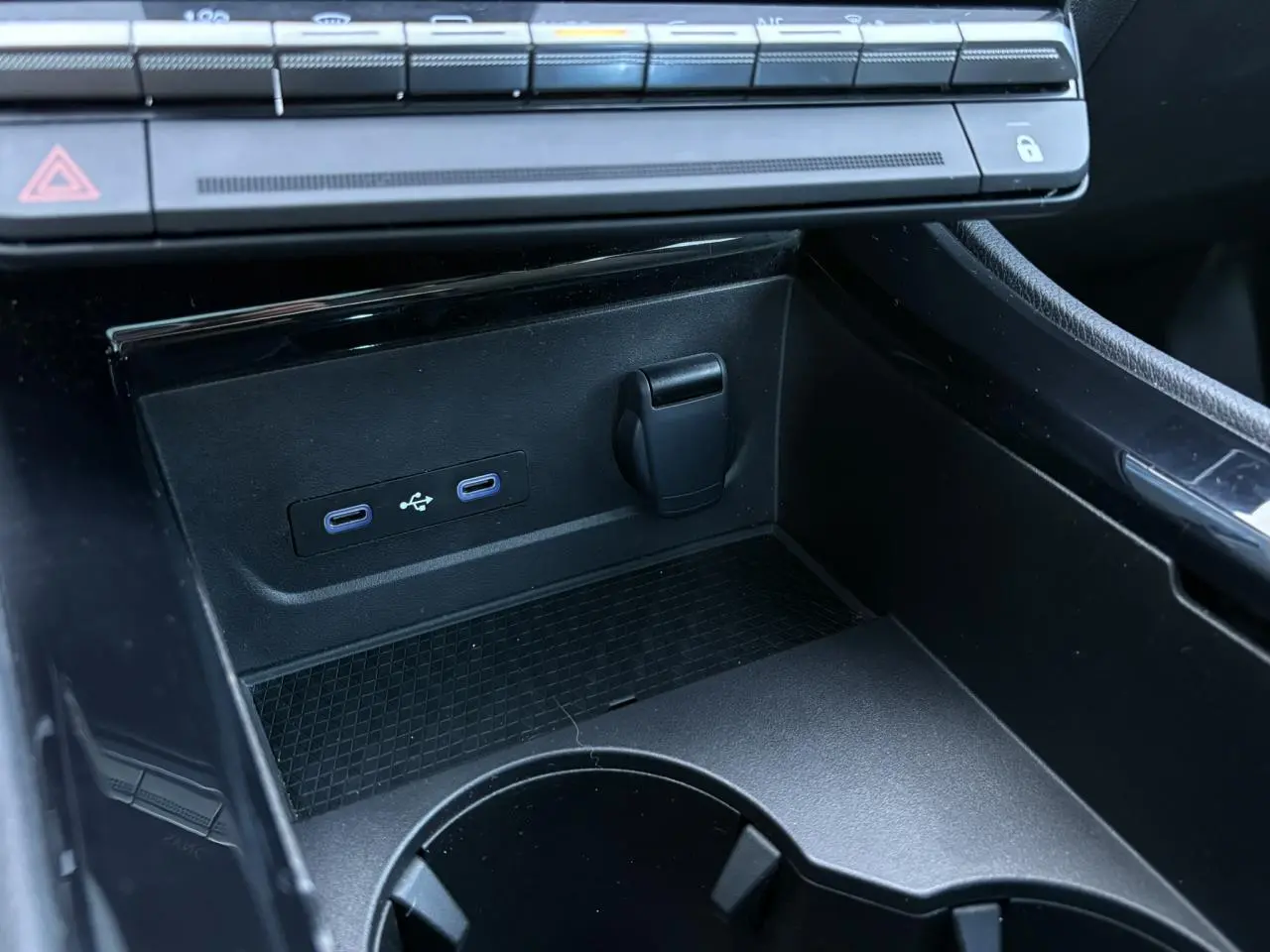 Prise USB double et prise 12V dans la console centrale noire du Renault Austral E-Tech 2024.