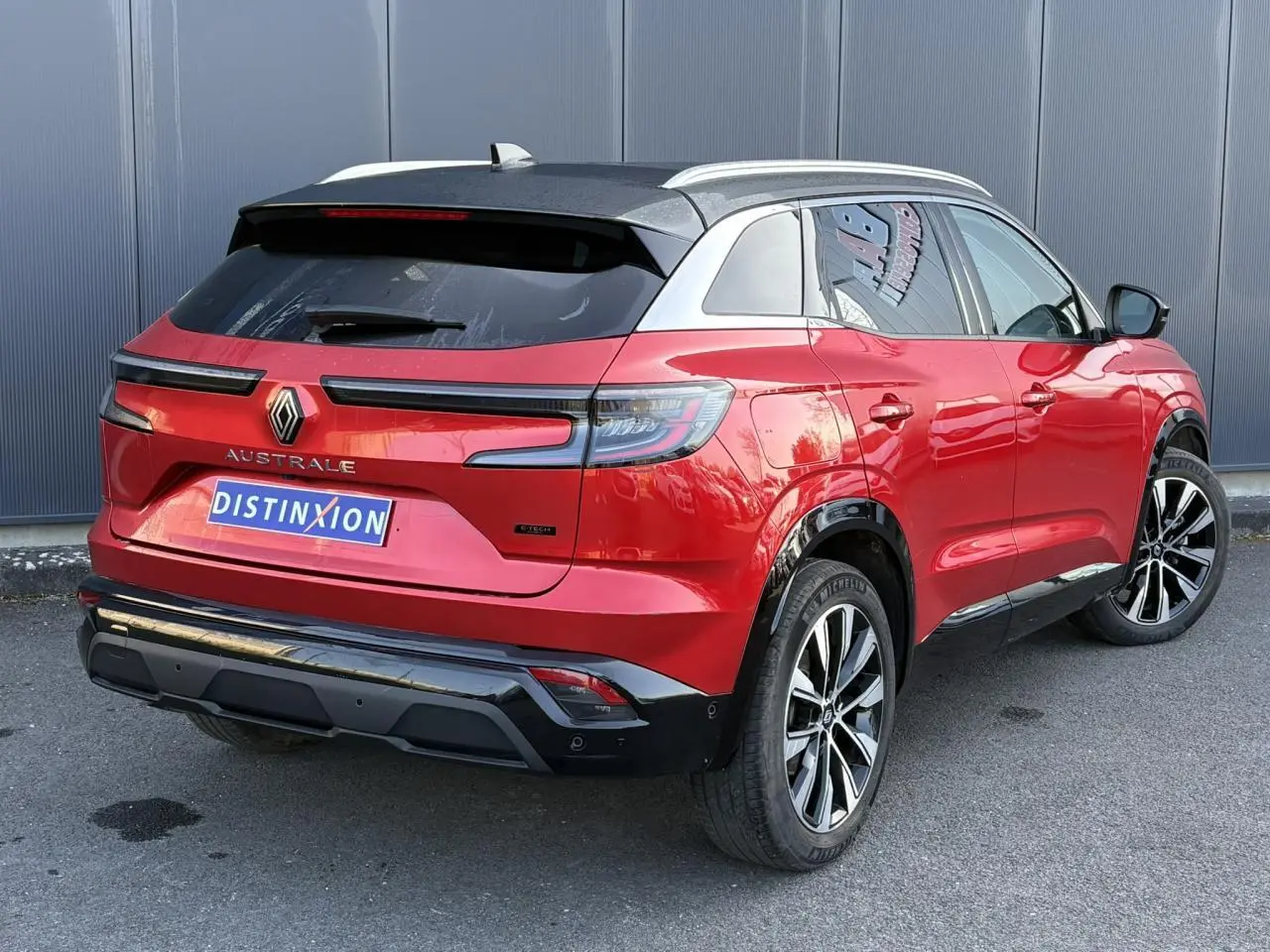 Vue 3/4 arrière droite du Renault Austral rouge Flamme avec toit noir et jantes alliage 19 pouces.