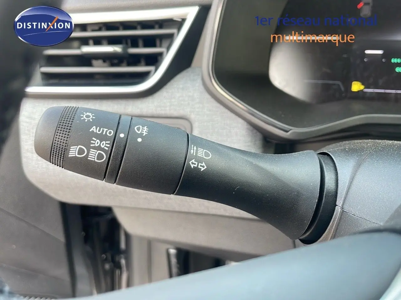 Gros plan sur la commande des feux et clignotants dans l'habitacle d'une Renault Clio gris schiste métal 2025.