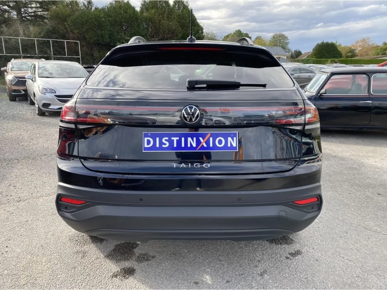 Vue arrière d'un Volkswagen Taigo noir intense avec logo et feux arrière allongés en extérieur.