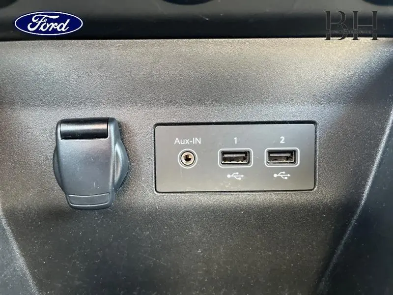 Vue rapprochée des prises auxiliaire et USB dans l'habitacle d'une Renault Clio gris Platine 2023.