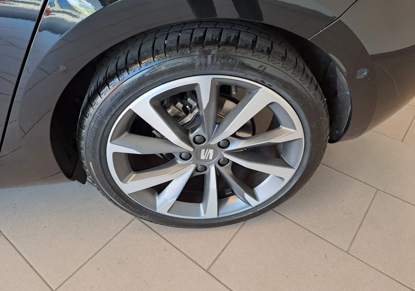 Gros plan sur la jante alliage argentée et pneu Bridgestone du côté arrière droit d'une SEAT LEON Noir Minuit 2024.