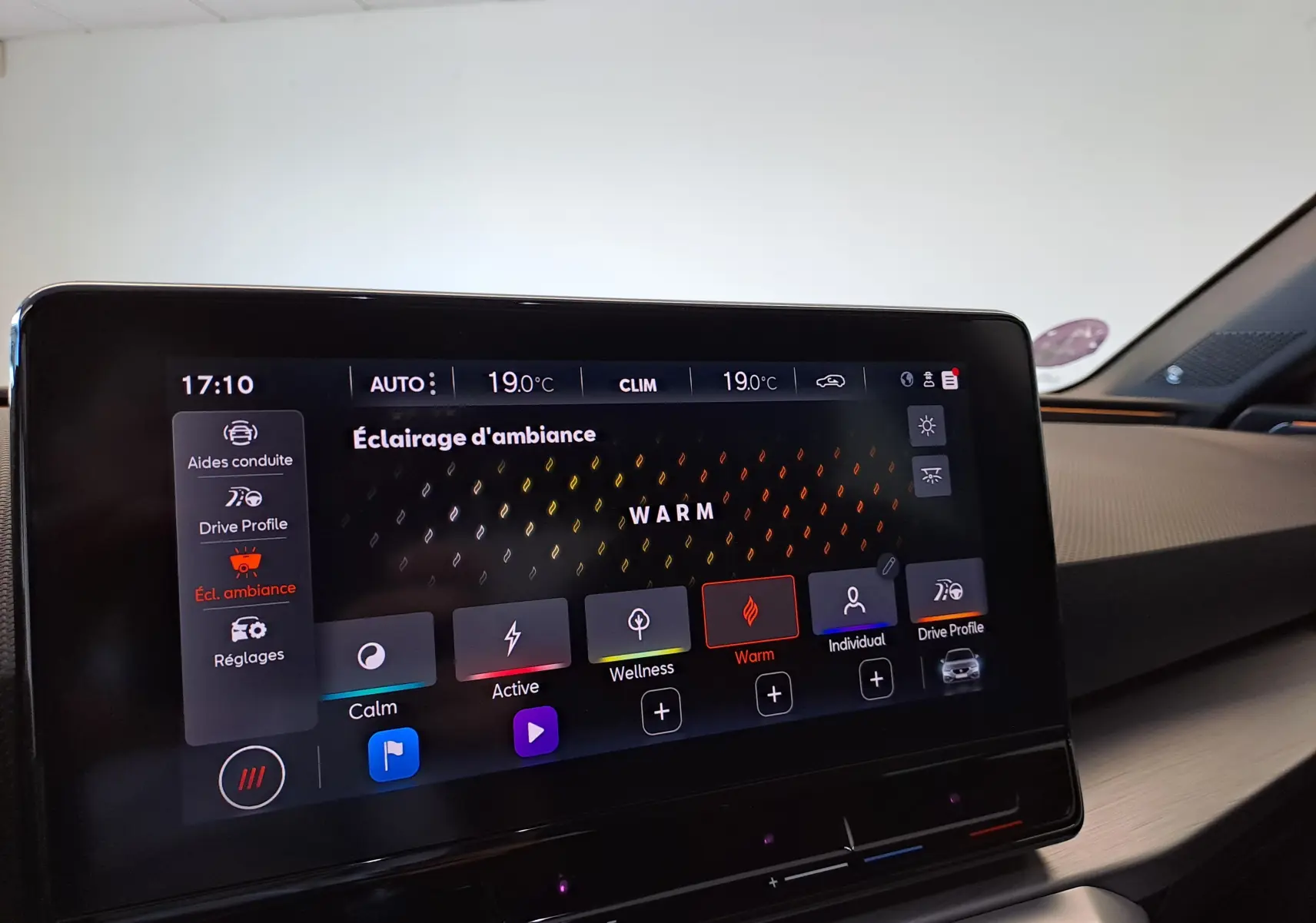 Écran tactile intérieur du SEAT LEON 1.5 eTSI Hybrid 2024 affichant les réglages d’éclairage d’ambiance en mode Warm.