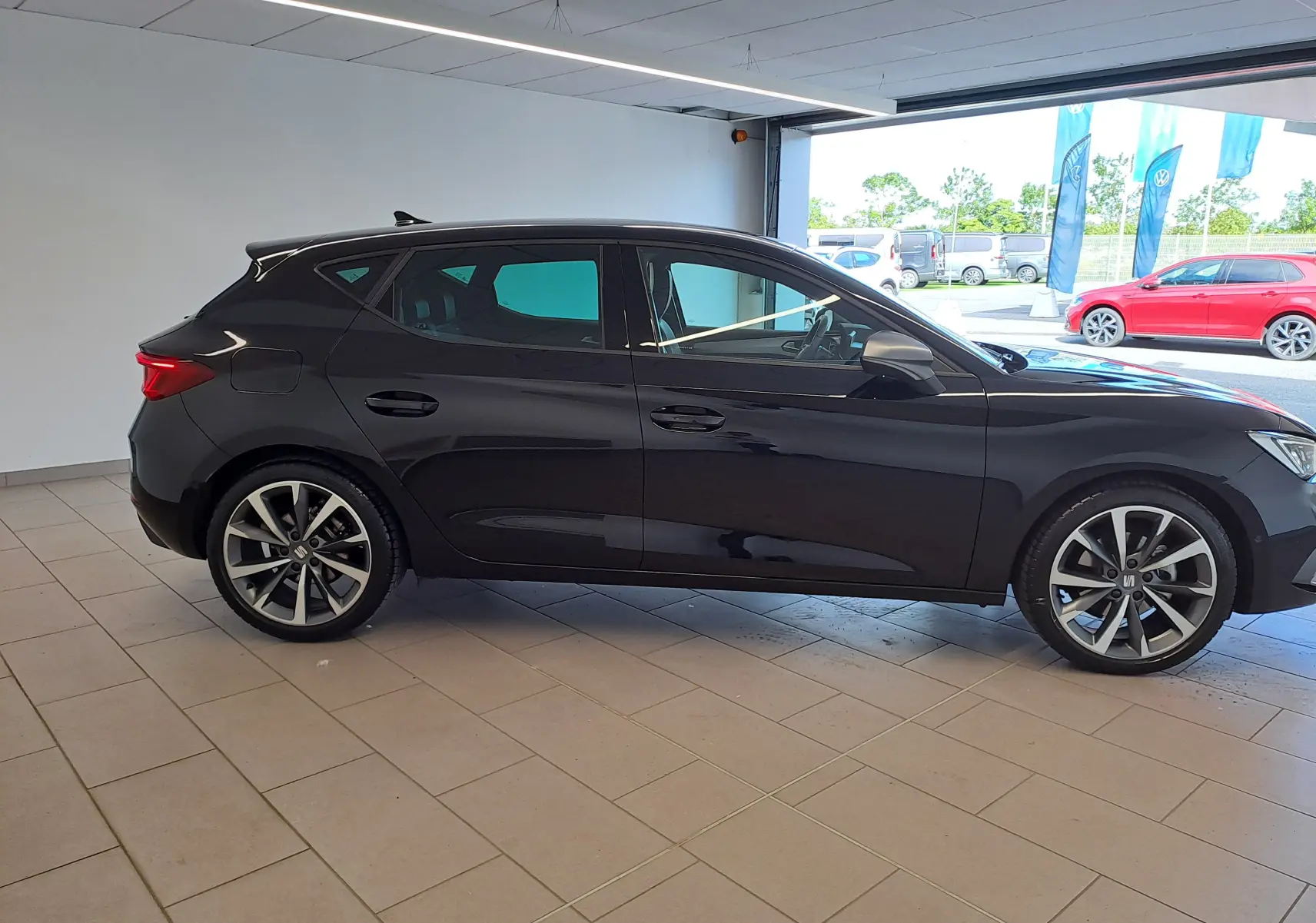Profil côté gauche de la SEAT LEON 1.5 eTSI Hybrid 150 DSG7 FR 2024 en noir minuit, avec jantes alliage distinctives.