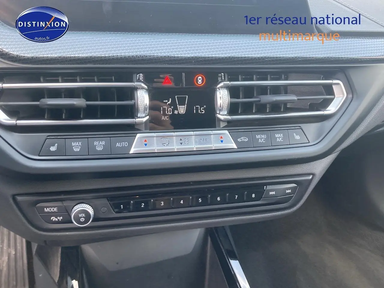 Tableau de bord et console centrale de BMW Série 1 gris foncé, avec commandes climatisation et radio visibles.