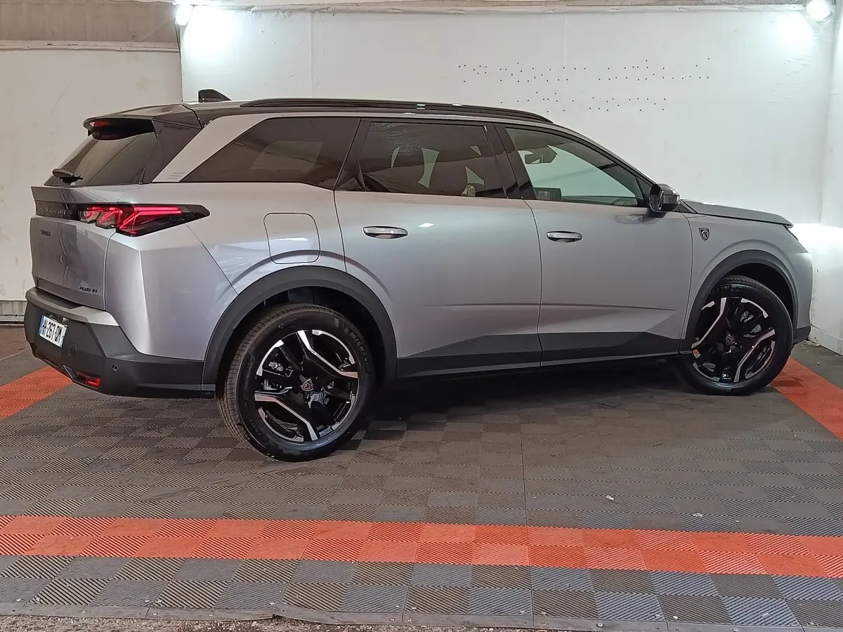 Vue de profil côté droit d’un Peugeot 5008 gris clair 2026 avec jantes noires et feux arrière LED distinctifs.