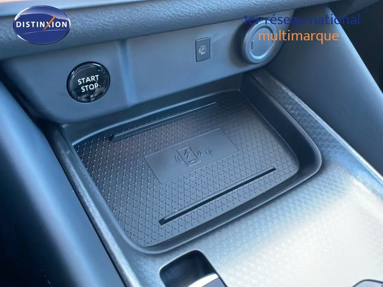 Détail de la console centrale avec zone de recharge sans fil et bouton start/stop du Nissan Qashqai 2025 gris argile métal.