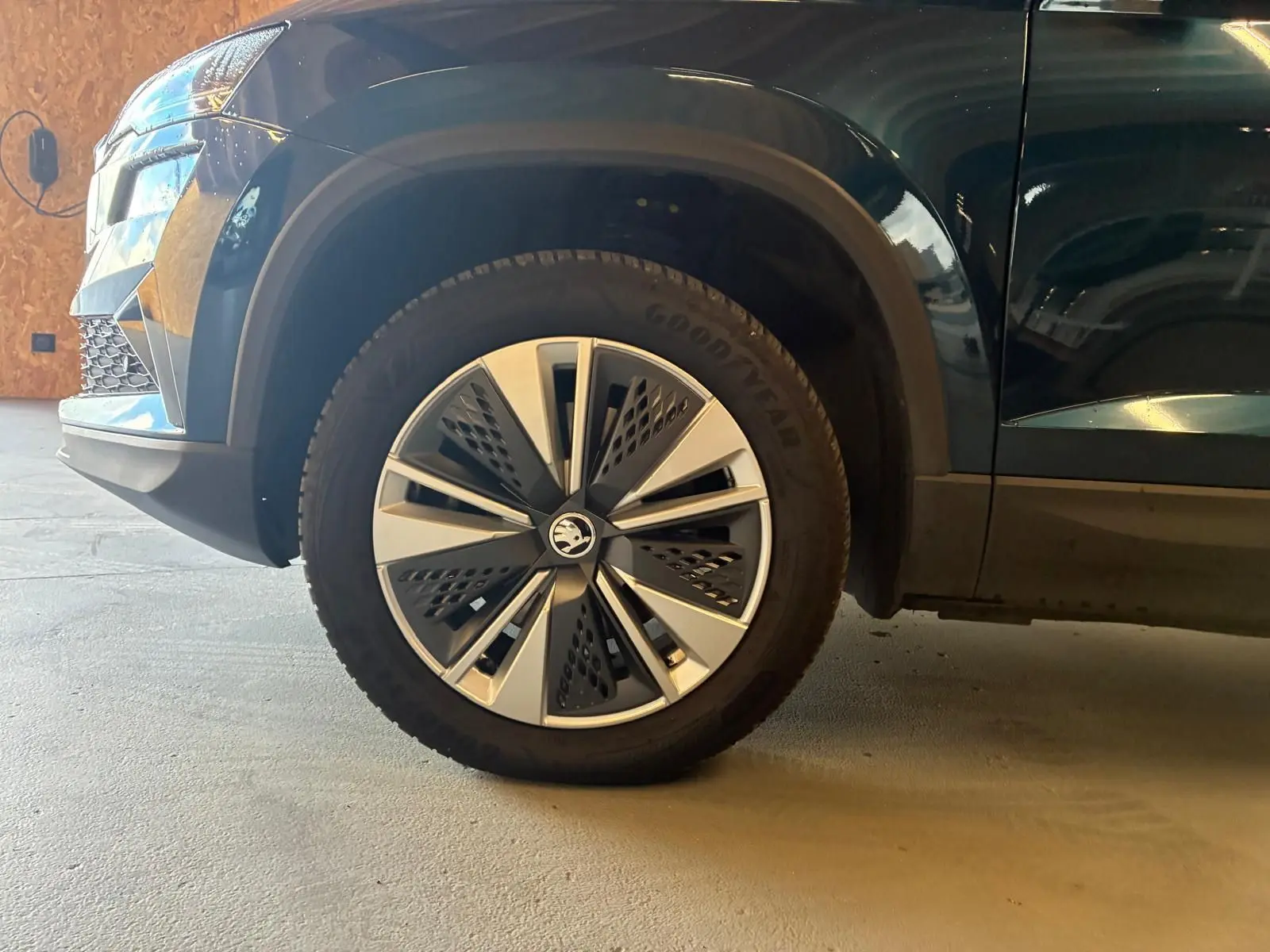 Gros plan sur la roue avant gauche et partie latérale d’un Skoda Karoq bleu avec jante alu 17 pouces design moderne.