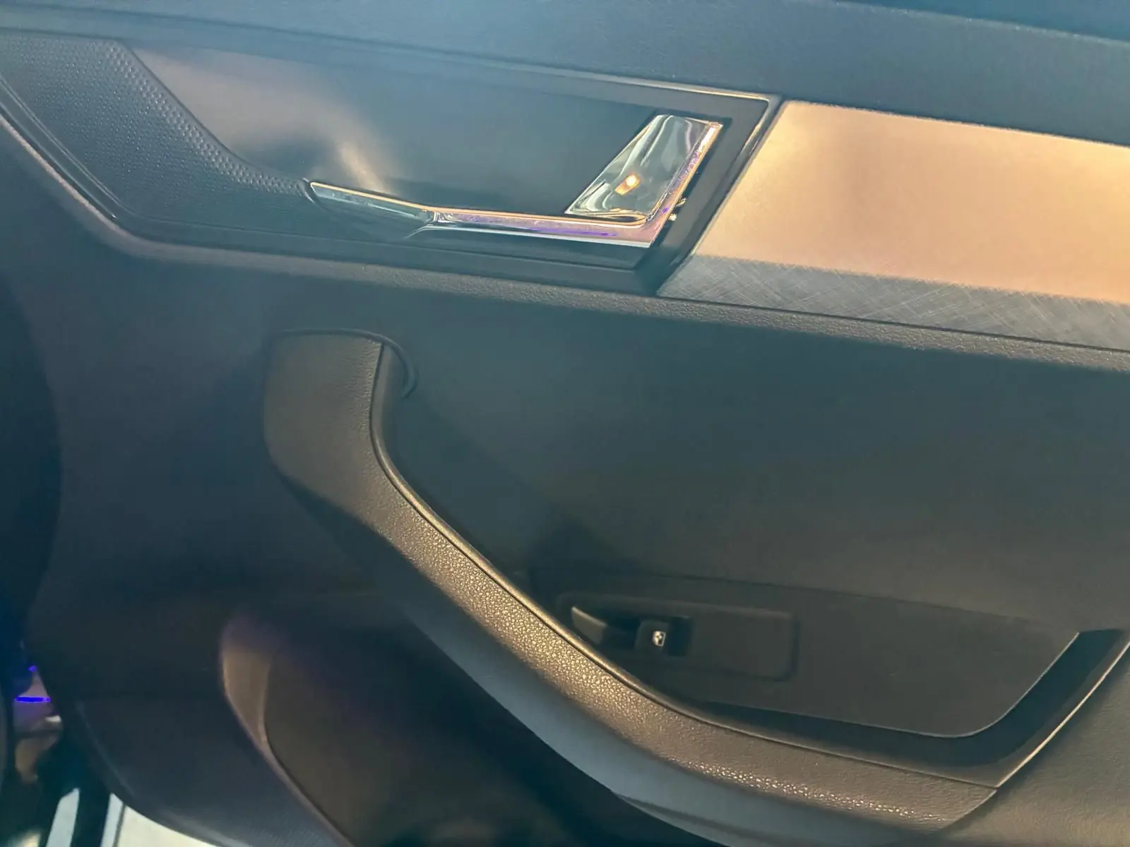 Détail de la poignée de porte intérieure noire avec insert chromé sur Skoda Karoq 2.0 TDI 116 DSG7 Business 2023.