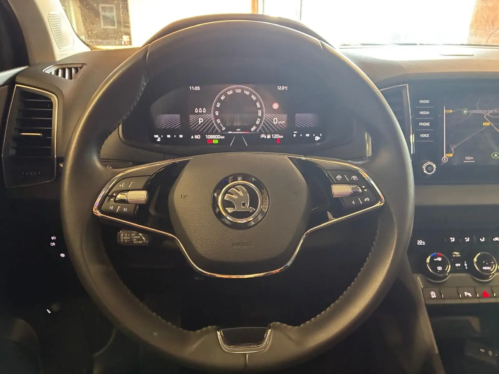 Vue rapprochée du volant noir multifonctions de la Skoda Karoq 2023 avec tableau de bord digital et écran tactile.