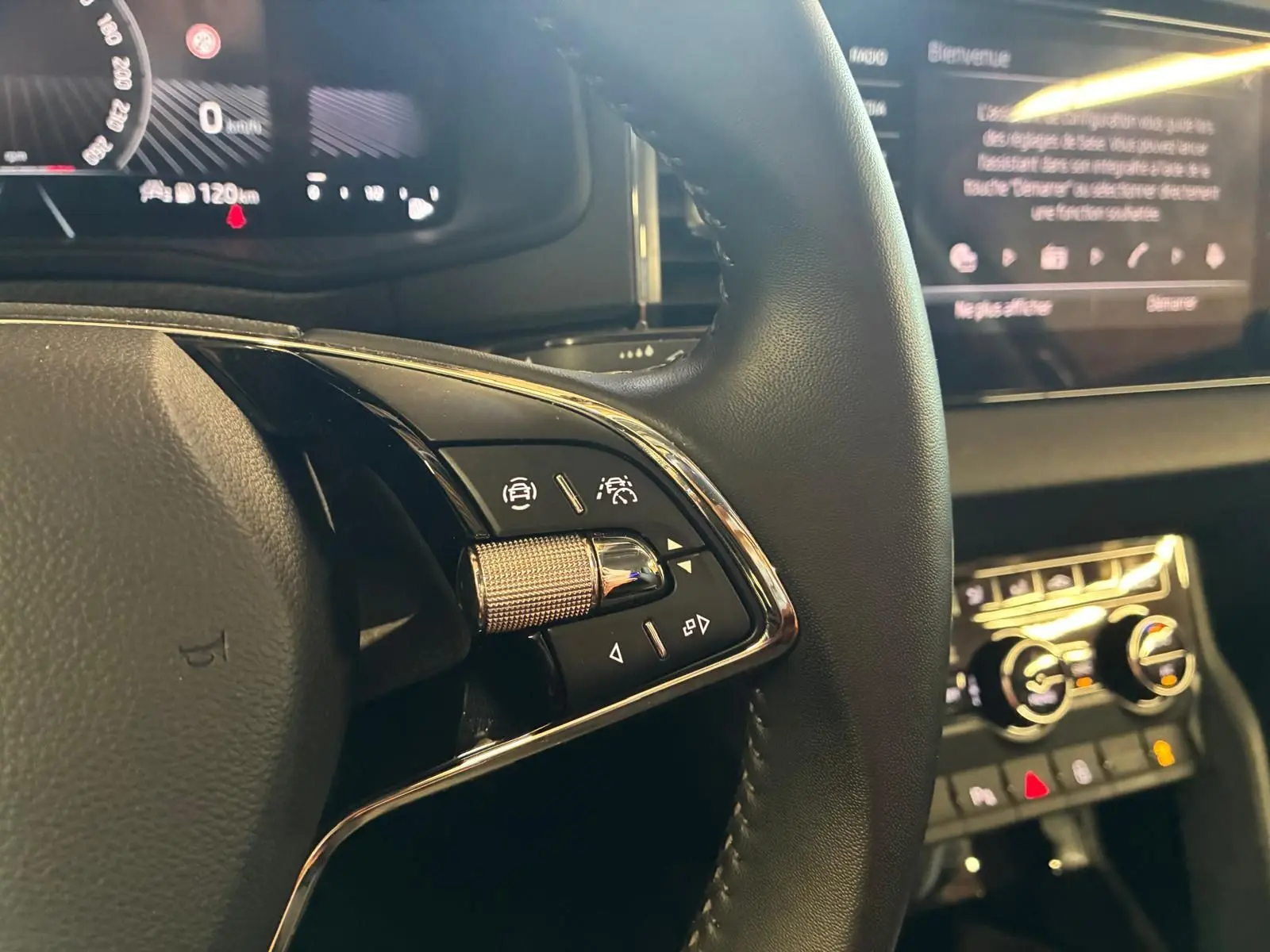 Gros plan sur le volant multifonctions en cuir avec commandes intégrées du Skoda Karoq 2023, intérieur noir.