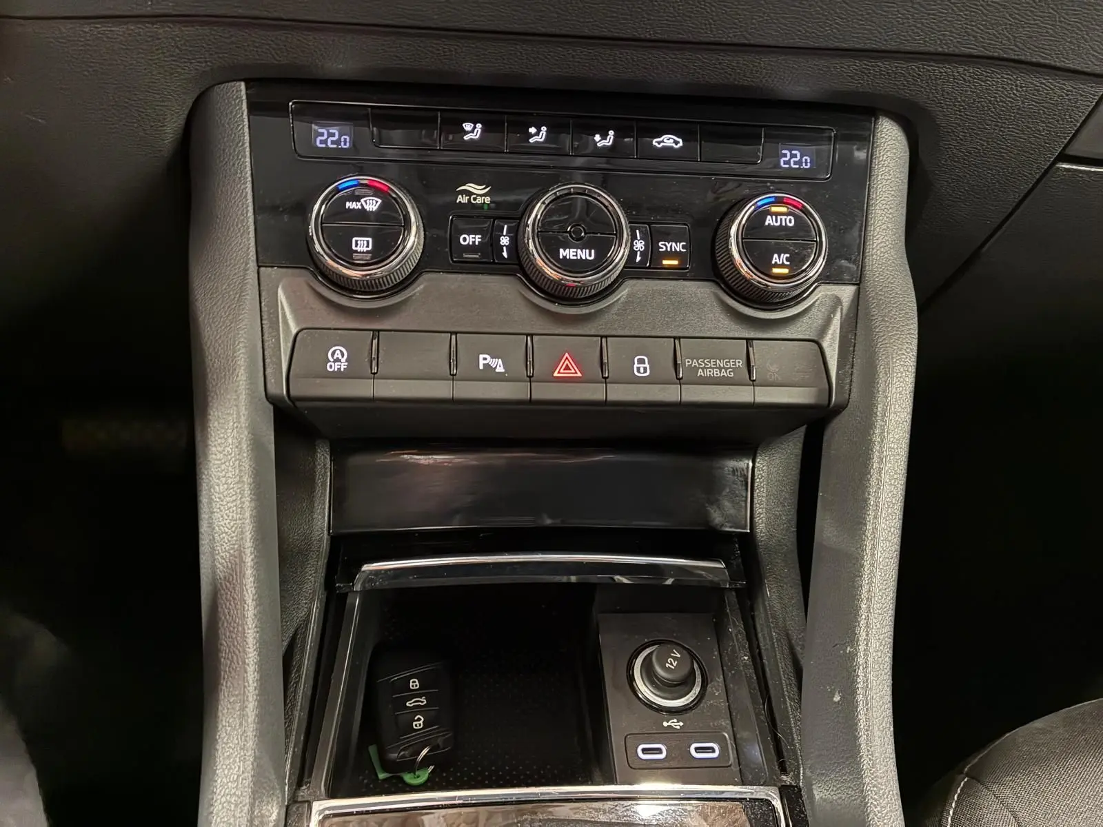 Vue rapprochée du tableau de bord central d'une Skoda Karoq 2023, montrant la climatisation automatique et les ports USB-C.