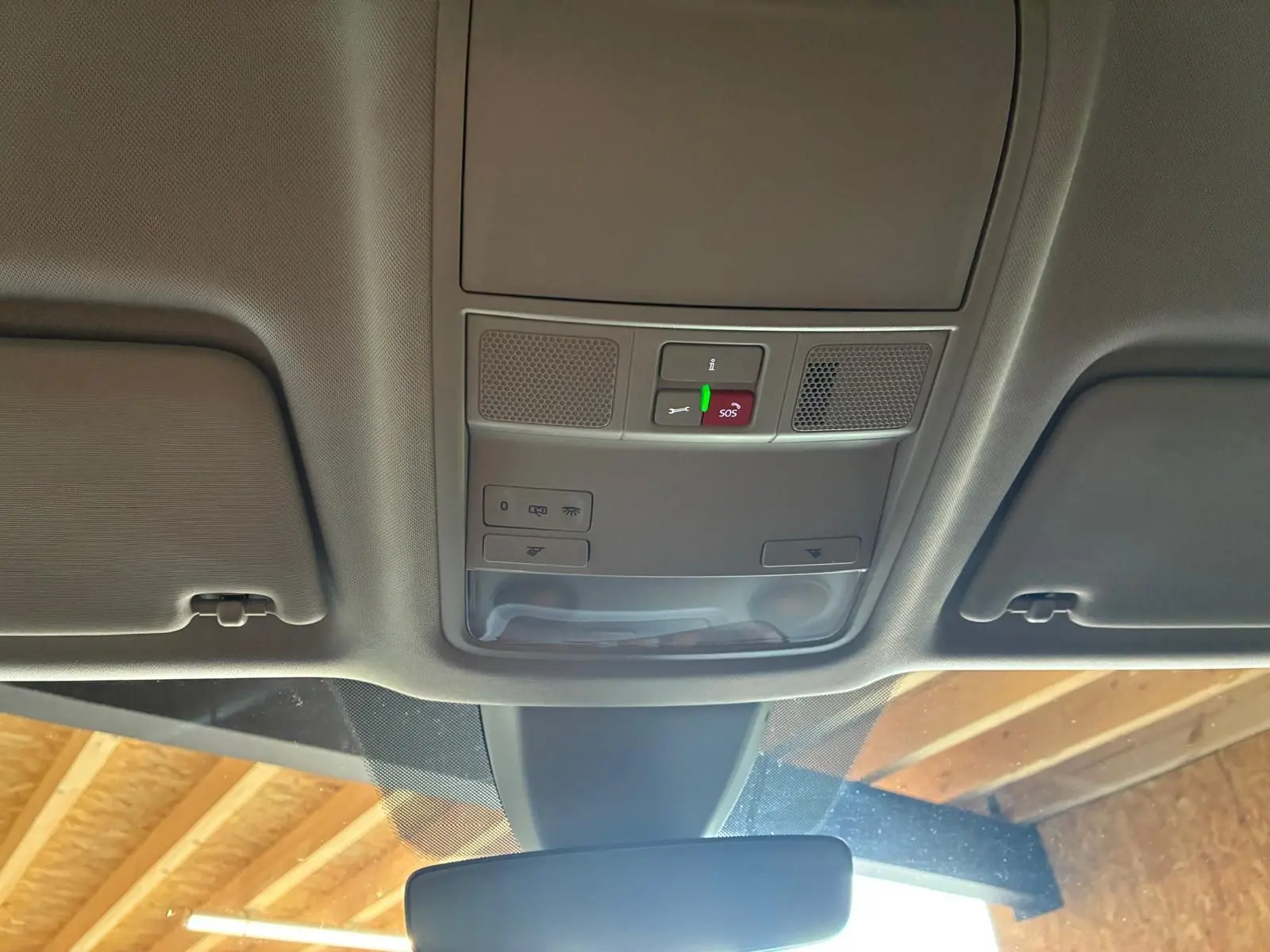 Vue intérieure du plafonnier gris avec commandes d'éclairage et bouton SOS du Skoda Karoq 2023 bleu.