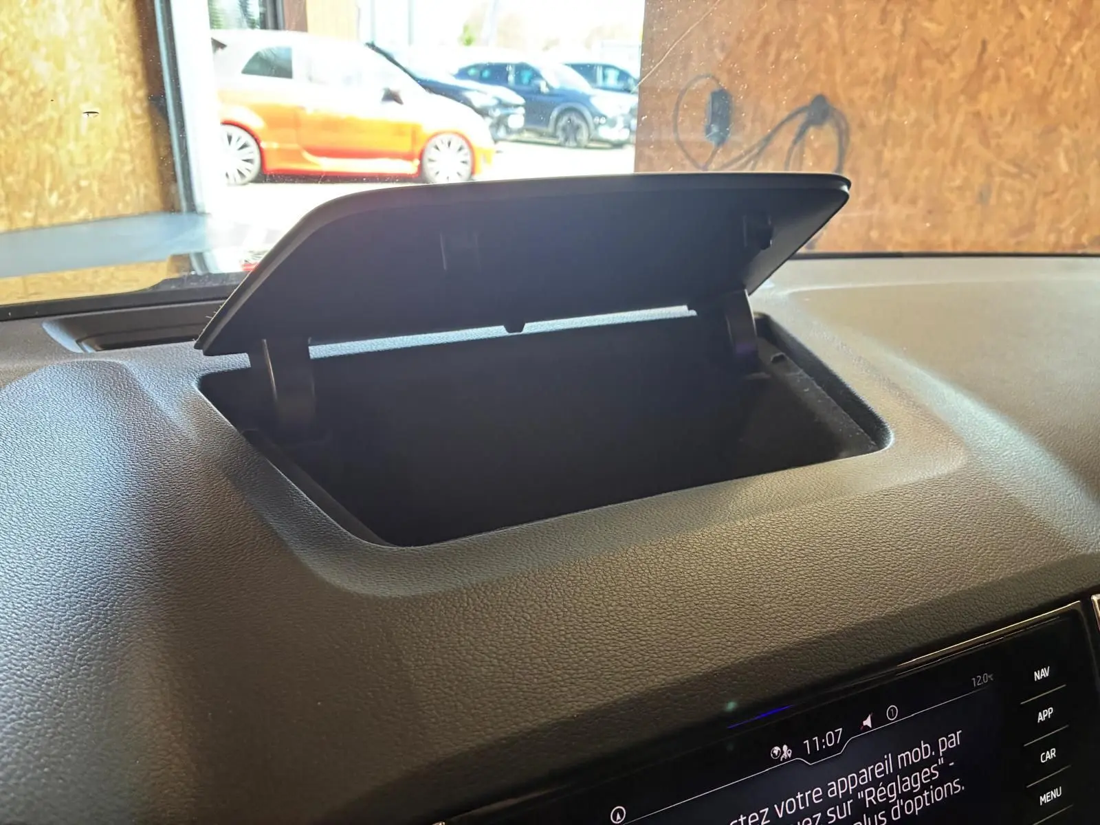 Vue intérieure du coffre à lunettes ouvert sur le tableau de bord noir d'une Skoda Karoq 2.0 TDI bleu 2023.