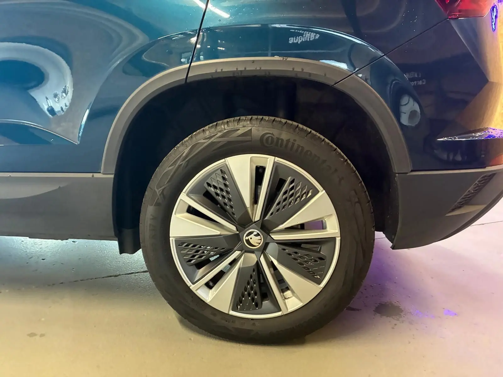Gros plan sur la roue arrière droite d’un Skoda Karoq bleu 2023 avec jante alu 17 pouces au design moderne.