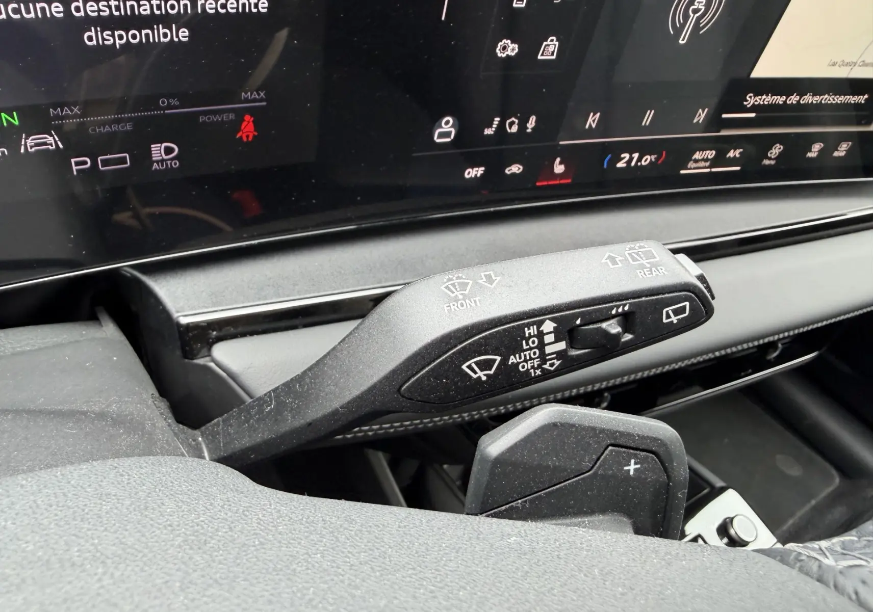Gros plan sur la commande des essuie-glaces et palettes au volant de l’Audi Q6 e-tron 2024 avec tableau de bord numérique.