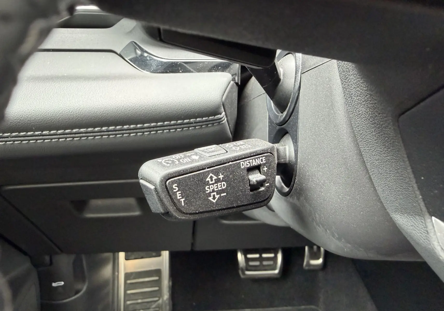 Gros plan sur le levier de commande de régulateur de vitesse dans l’habitacle gris foncé de l’Audi Q6 e-tron 2024.