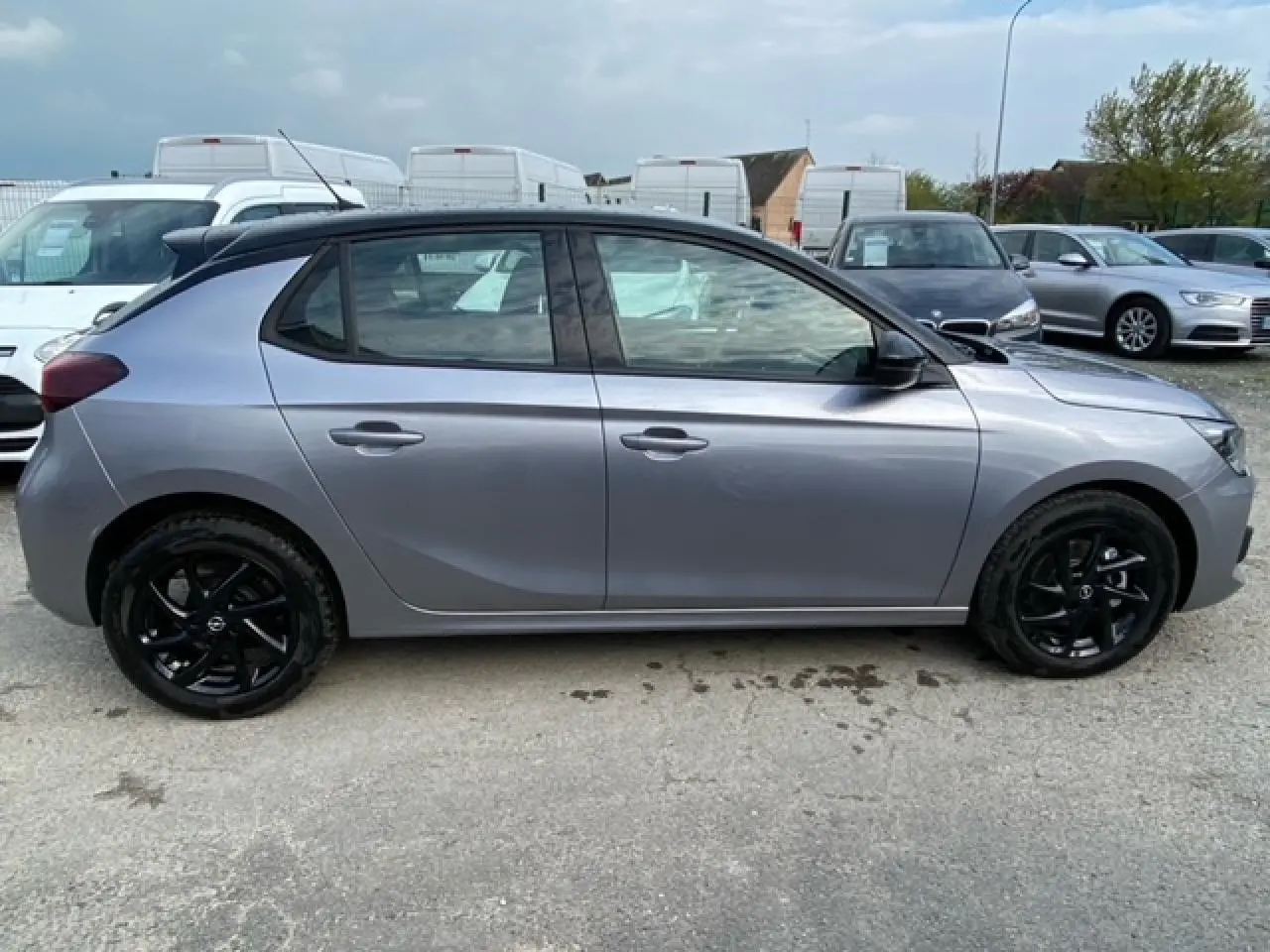 Profil côté droit d'une Opel Corsa 2022 gris magnetic avec toit noir et jantes alliage noires brillantes.
