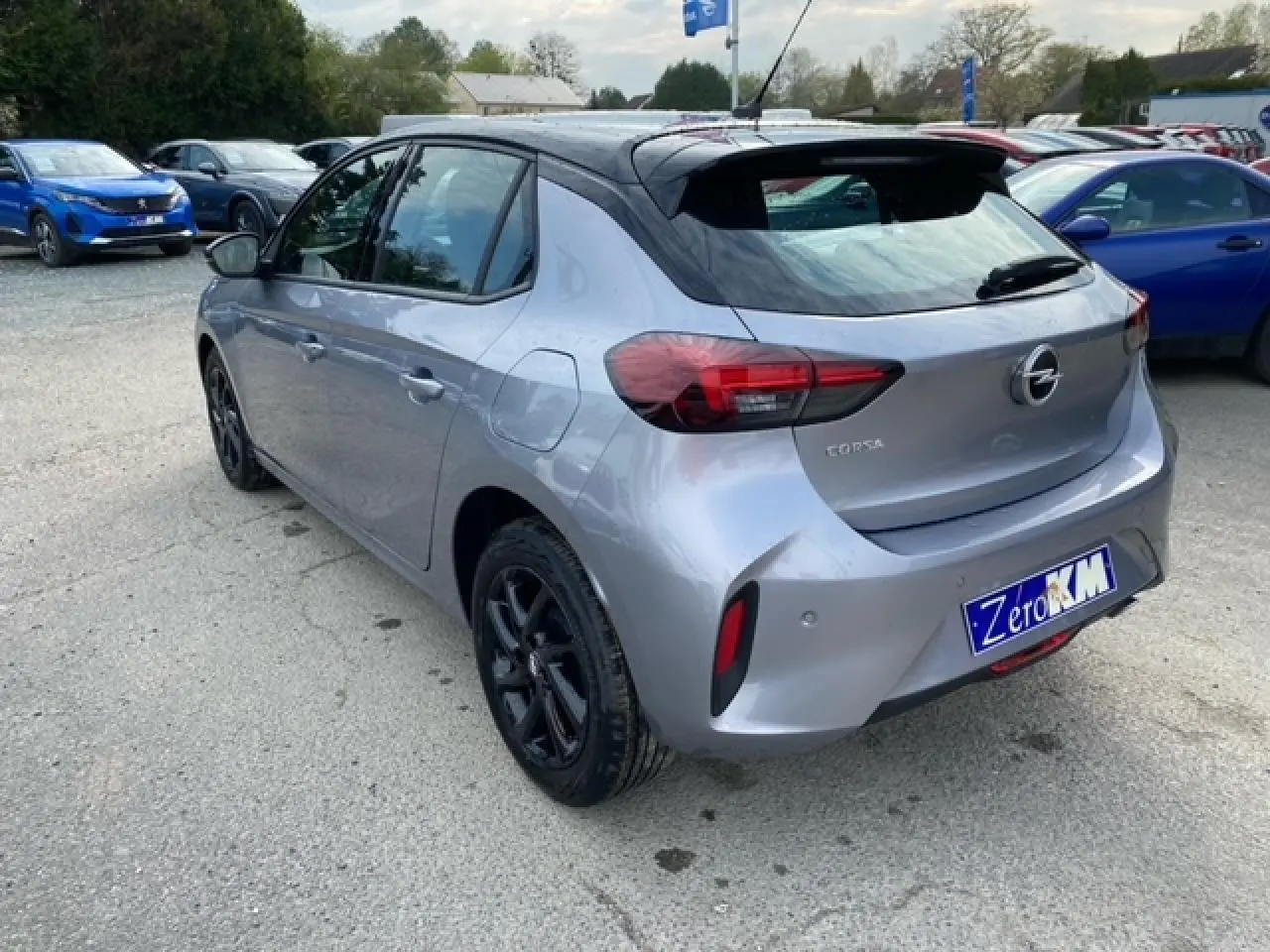 Vue 3/4 arrière gauche d'une Opel Corsa 2022 gris magnetic avec toit noir et jantes alliage noires brillantes.