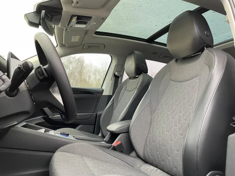 Vue intérieure avant du Volkswagen Tiguan 2025 avec sièges tissu anthracite et toit ouvrant panoramique.