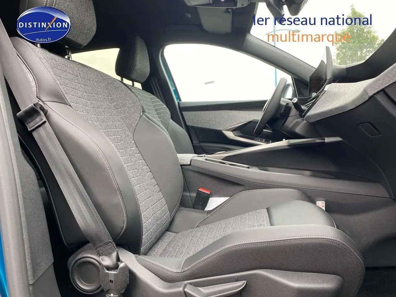 Vue intérieure côté conducteur du Peugeot 3008 bleu 2025, sièges tissu et cuir avec console centrale moderne.
