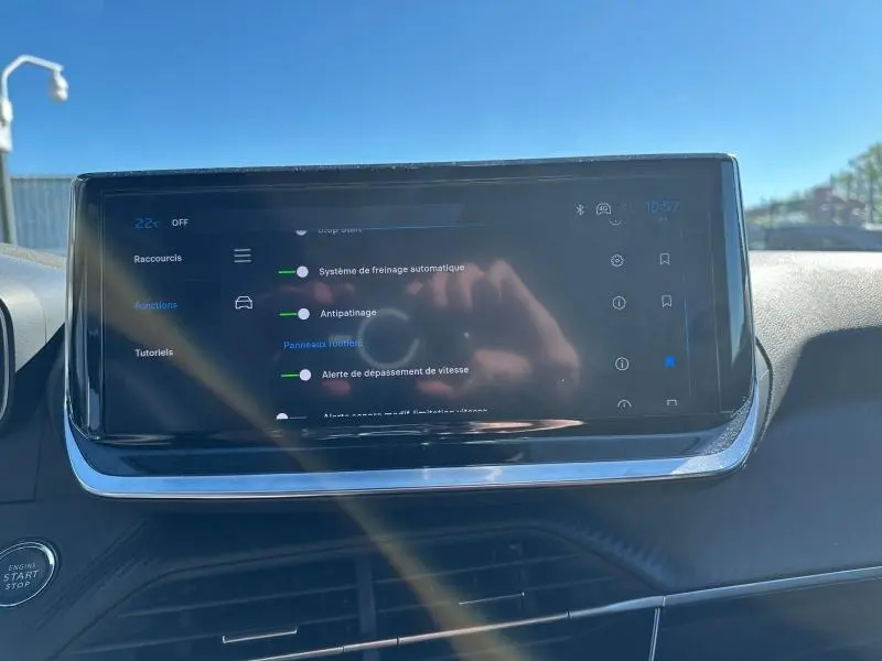 Écran tactile central du tableau de bord du Peugeot 2008 1.2 Hybrid 145ch Allure, affichant les options d’aide à la conduite.