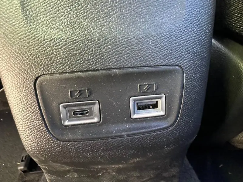 Gros plan sur deux ports USB de recharge situés à l'arrière d'un Peugeot 2008 hybride bleu, finition Allure.