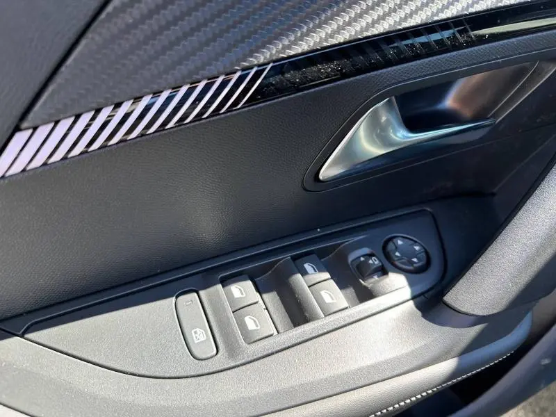 Détail de la porte côté conducteur du Peugeot 2008 2025 avec commandes électriques et poignée argentée.