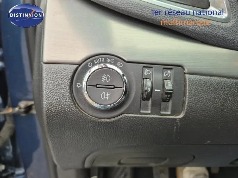 Gros plan sur les commandes d'éclairage du tableau de bord d'un Opel Mokka bleu outremer, version 2015.