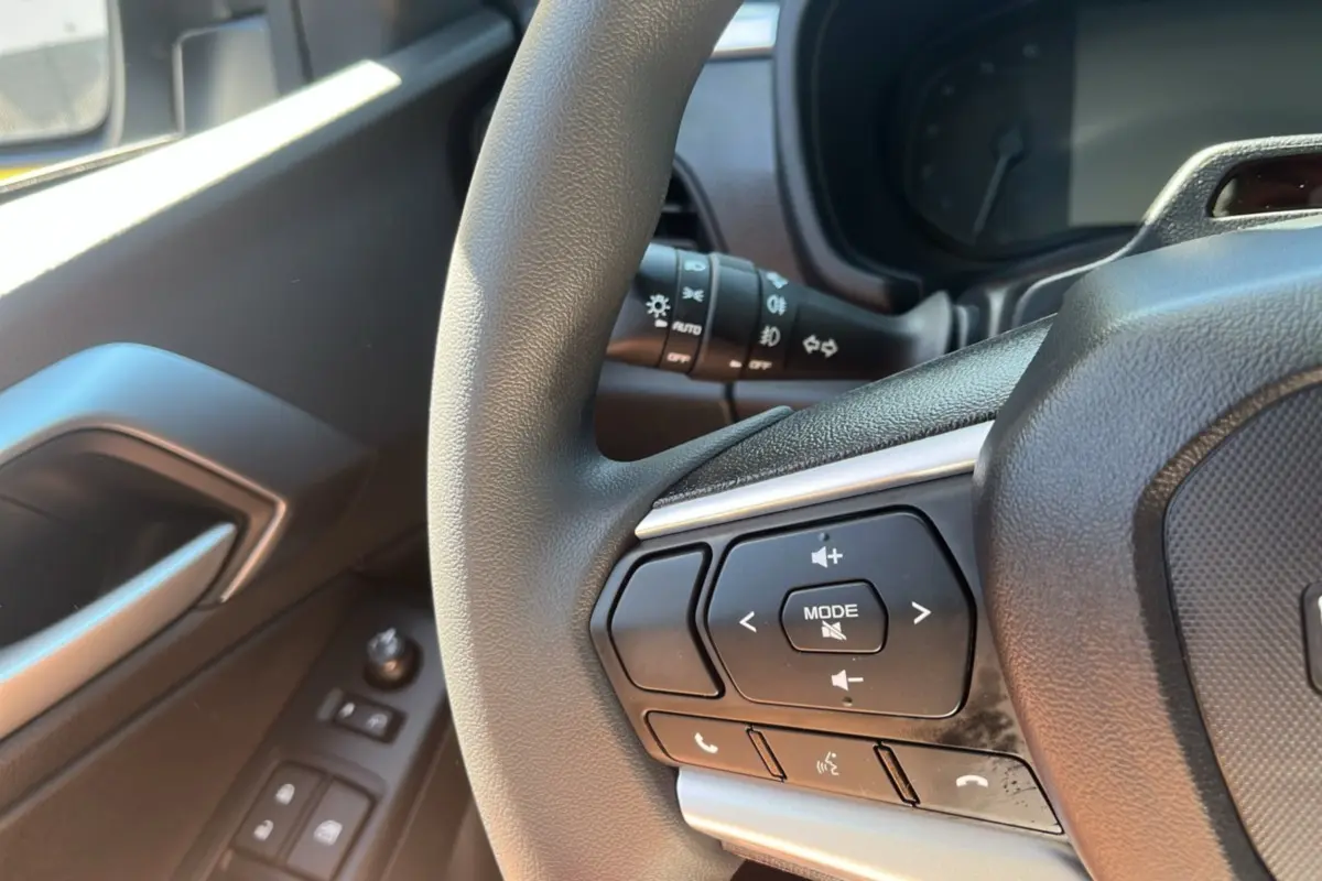 Gros plan sur le volant multifonctions côté gauche de l'Isuzu D-MAX 2026 avec commandes audio et téléphone.