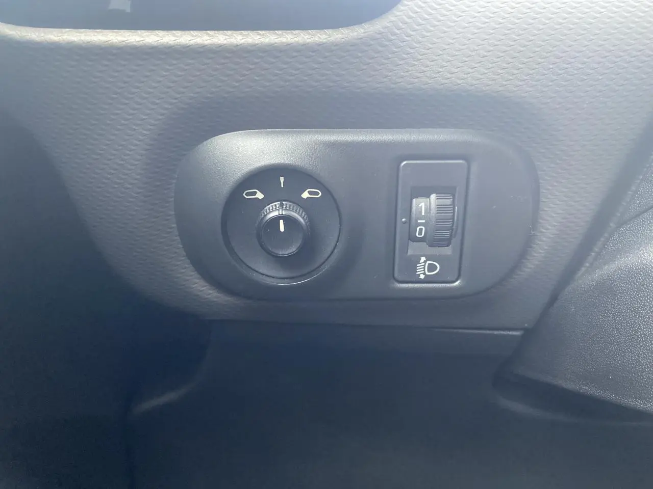 Gros plan sur les commandes de réglage des rétroviseurs et de l'éclairage du tableau de bord d'une Citroën C4 Cactus blanche.