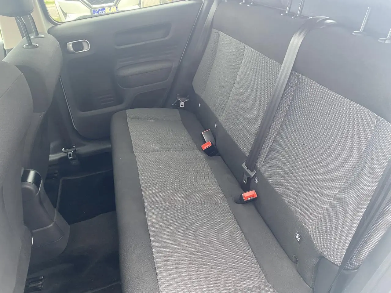 Vue intérieure de la banquette arrière grise du Citroën C4 Cactus 2015 avec ceintures et fixations ISOFIX visibles.