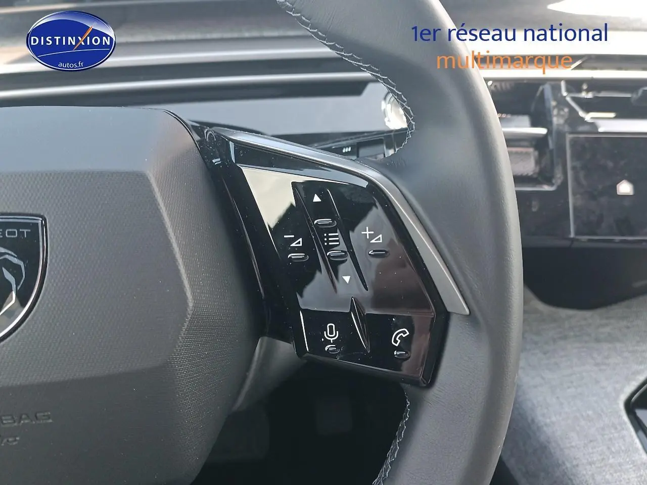 Gros plan sur le volant cuir noir du Peugeot 3008 2025 avec commandes multifonctions et tableau de bord tactile en arrière-plan.