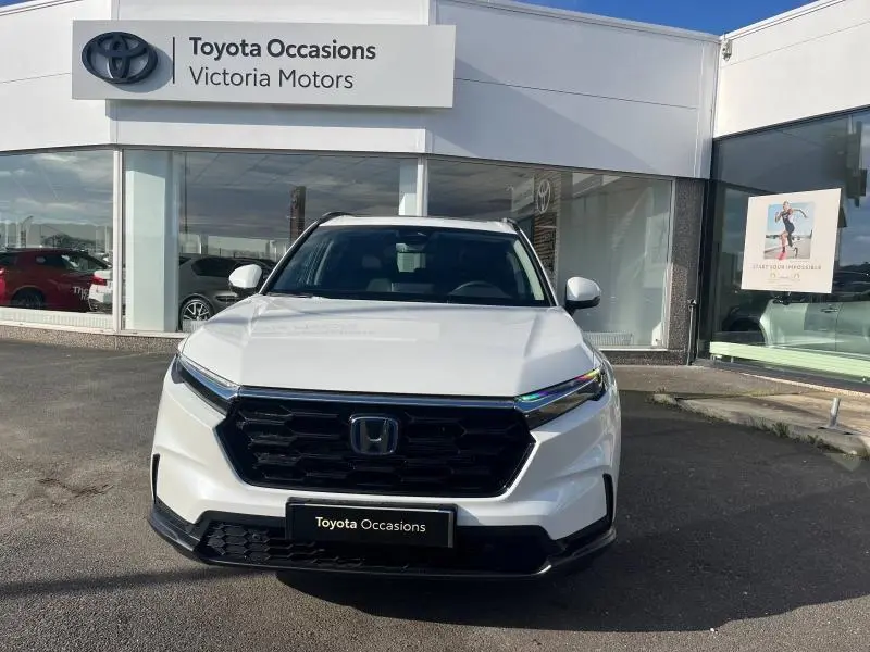 Vue avant d'un Honda CR-V 2024 blanc Diamant Brillant Premium métallisé, avec calandre noire et toit panoramique visible.