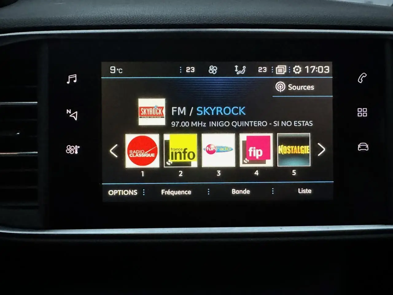 Écran tactile central du tableau de bord du Peugeot 308 gris Artense affichant les stations radio FM.