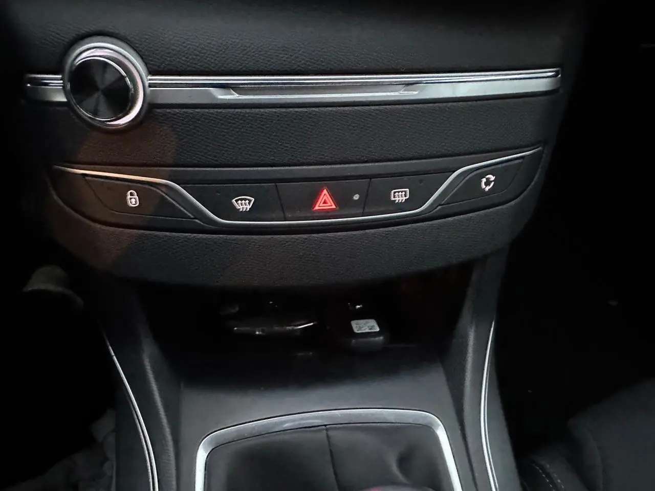 Vue rapprochée de la console centrale noire de la Peugeot 308 2018 avec boutons de sécurité et climatisation.