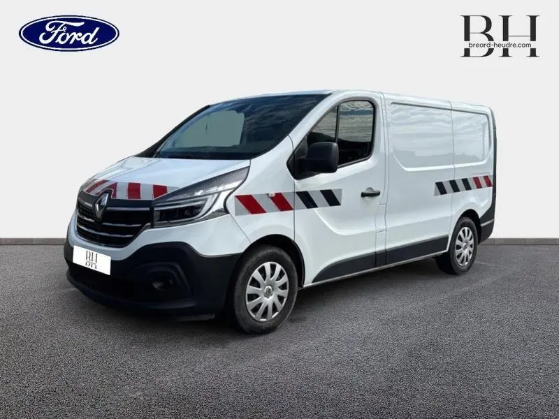 Renault Trafic Fourgon blanc glacier en 3/4 avant droit avec bandes réfléchissantes rouges et noires sur la carrosserie.