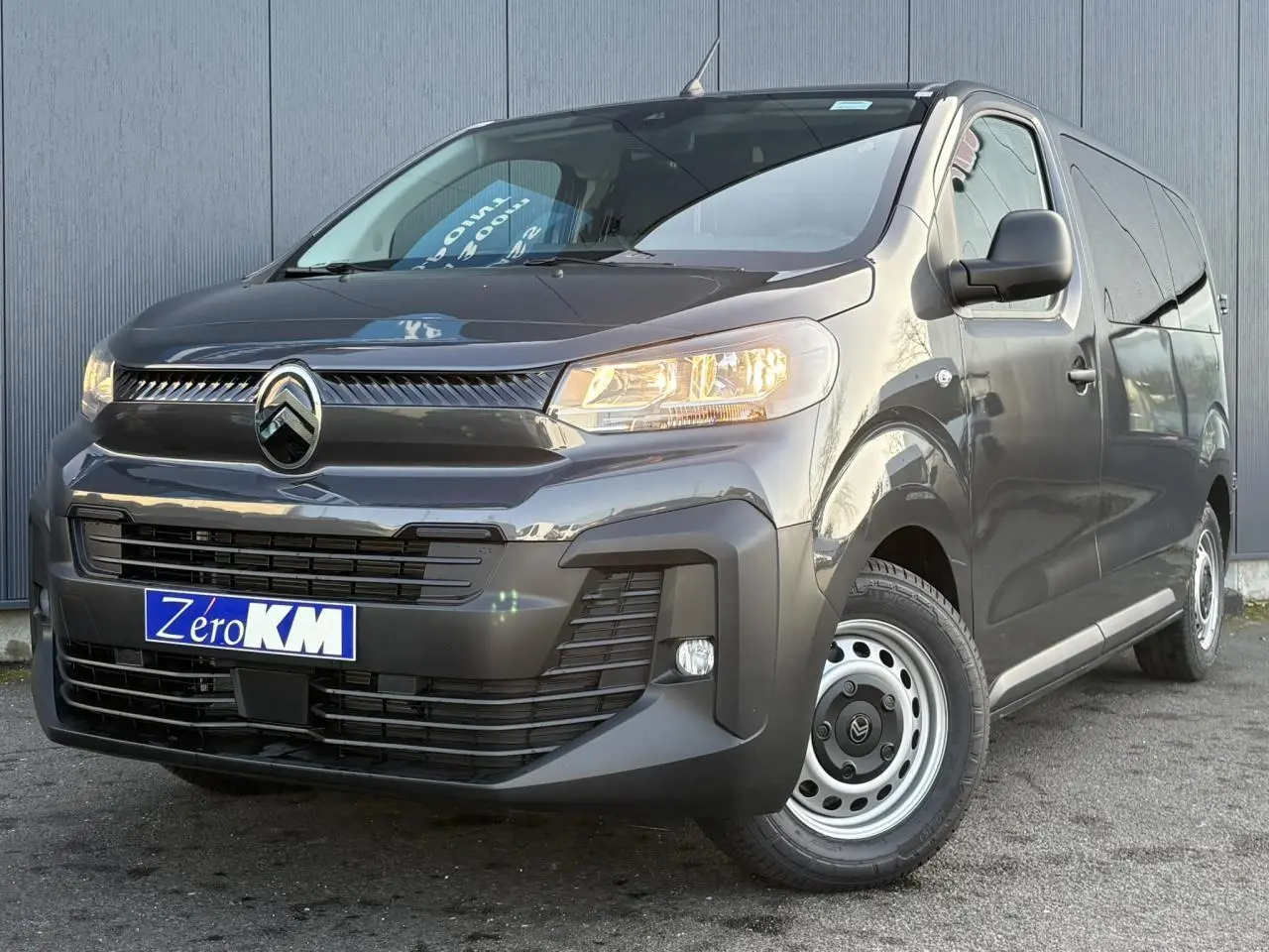Vue 3/4 avant droit du Citroën Jumpy gris titane avec calandre noire et jantes acier simples.