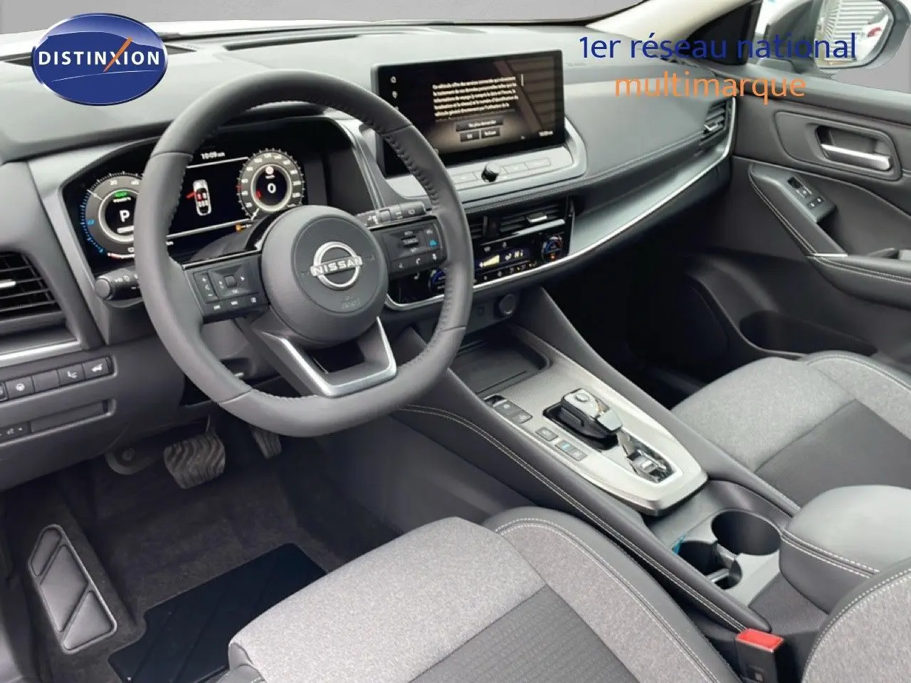 Vue intérieure côté conducteur du Nissan Qashqai blanc nacré 2025, mettant en valeur le tableau de bord digital et la console centrale moderne.