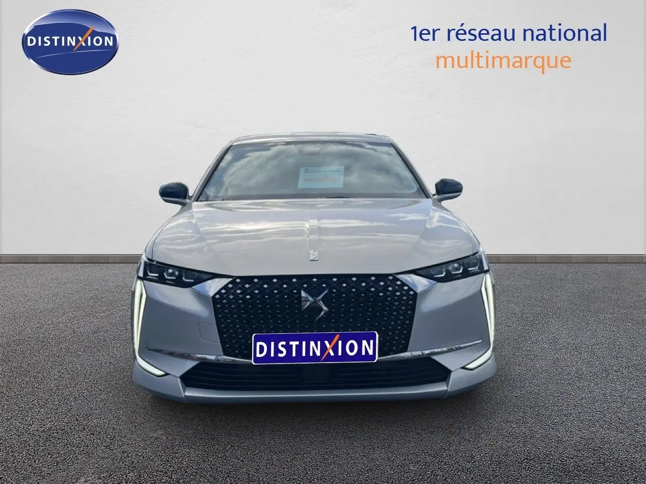 Vue frontale d'une DS4 2024 gris cristal pearl nacré avec calandre noire et feux LED verticaux distinctifs.