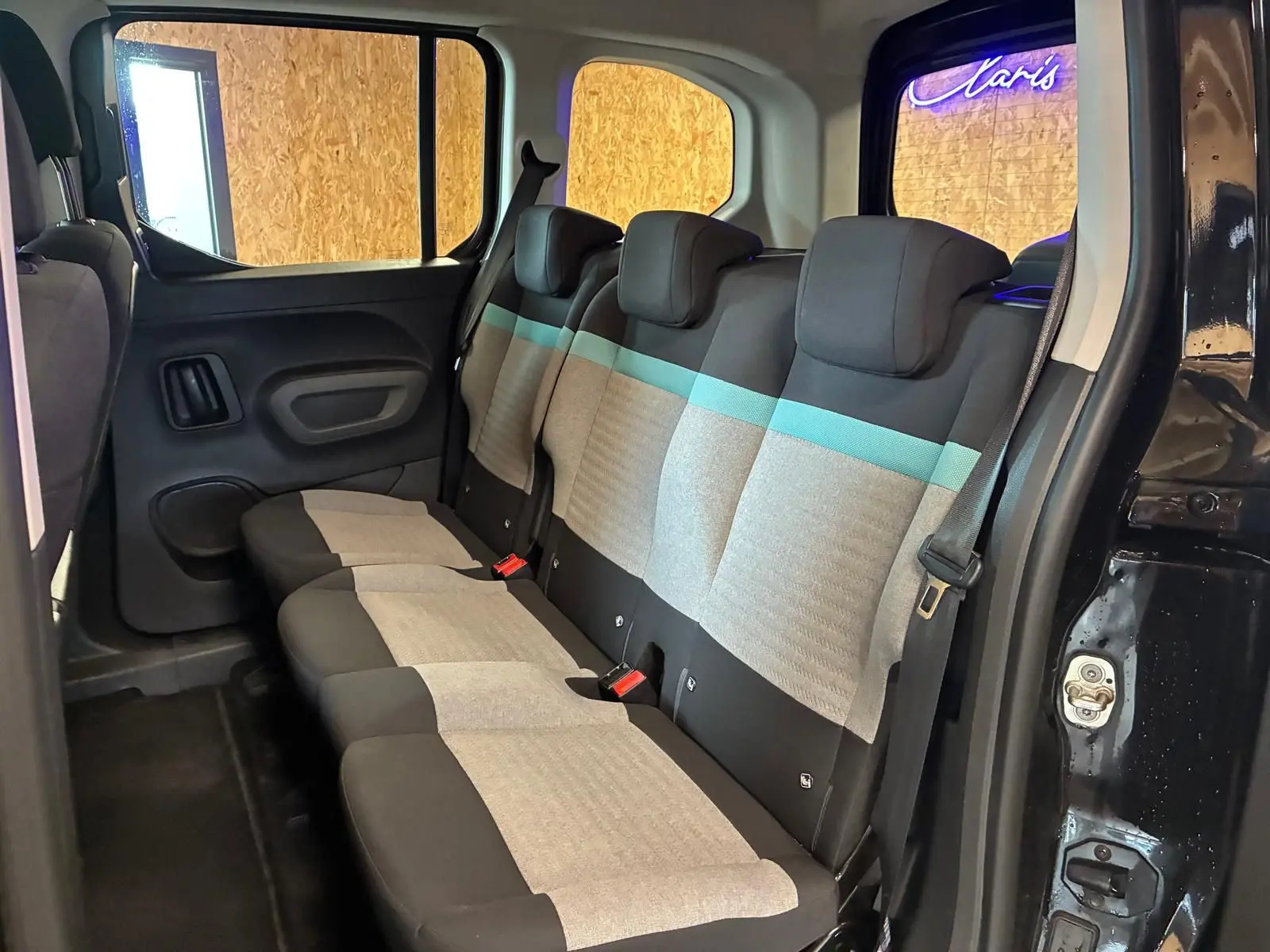 Vue intérieure côté droit des sièges arrière en tissu gris et noir avec bande turquoise du Citroën Berlingo noir 2020.