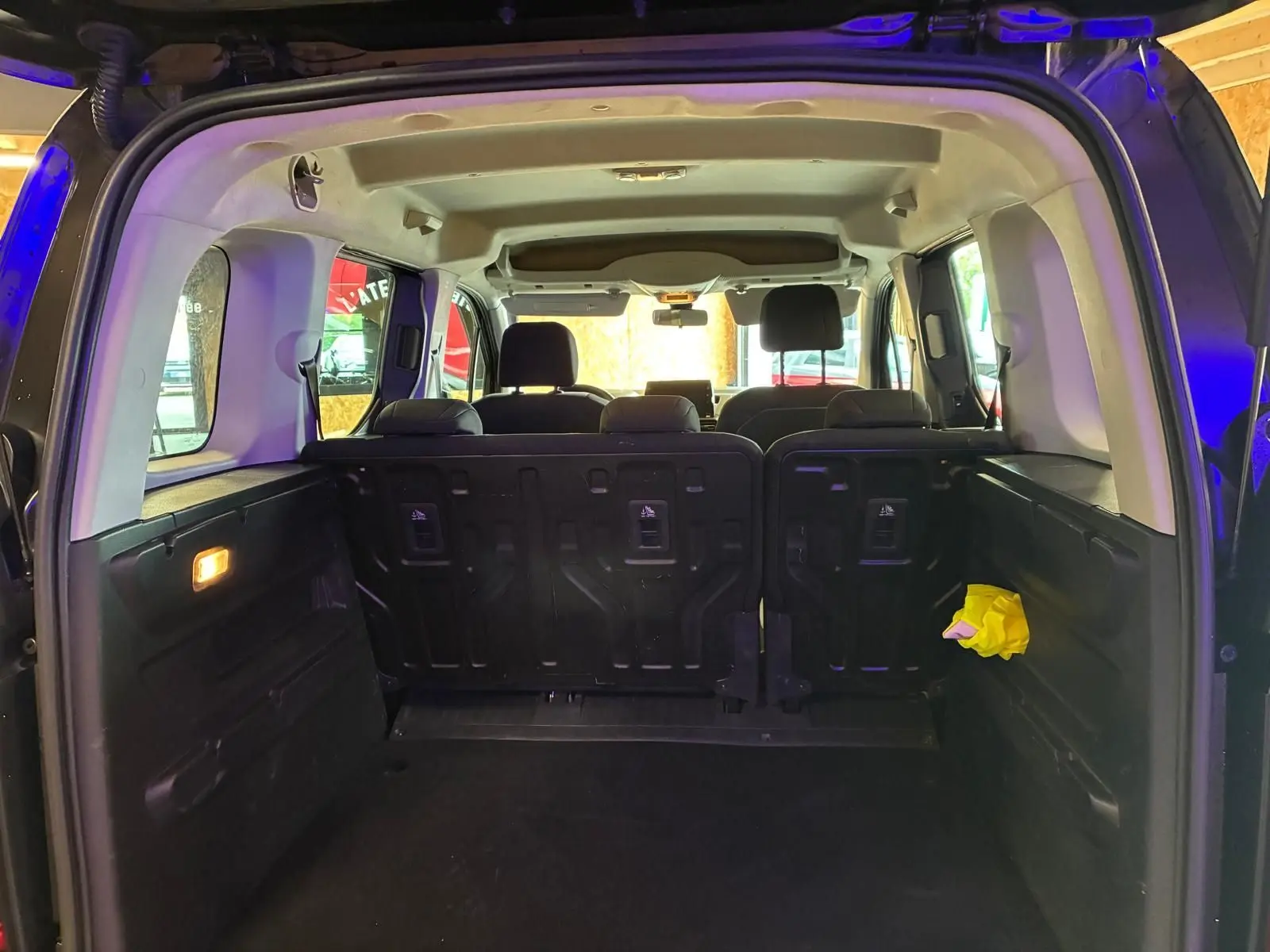 Vue intérieure arrière du Citroën Berlingo noir 2020, montrant le coffre spacieux et les sièges arrière en tissu noir.