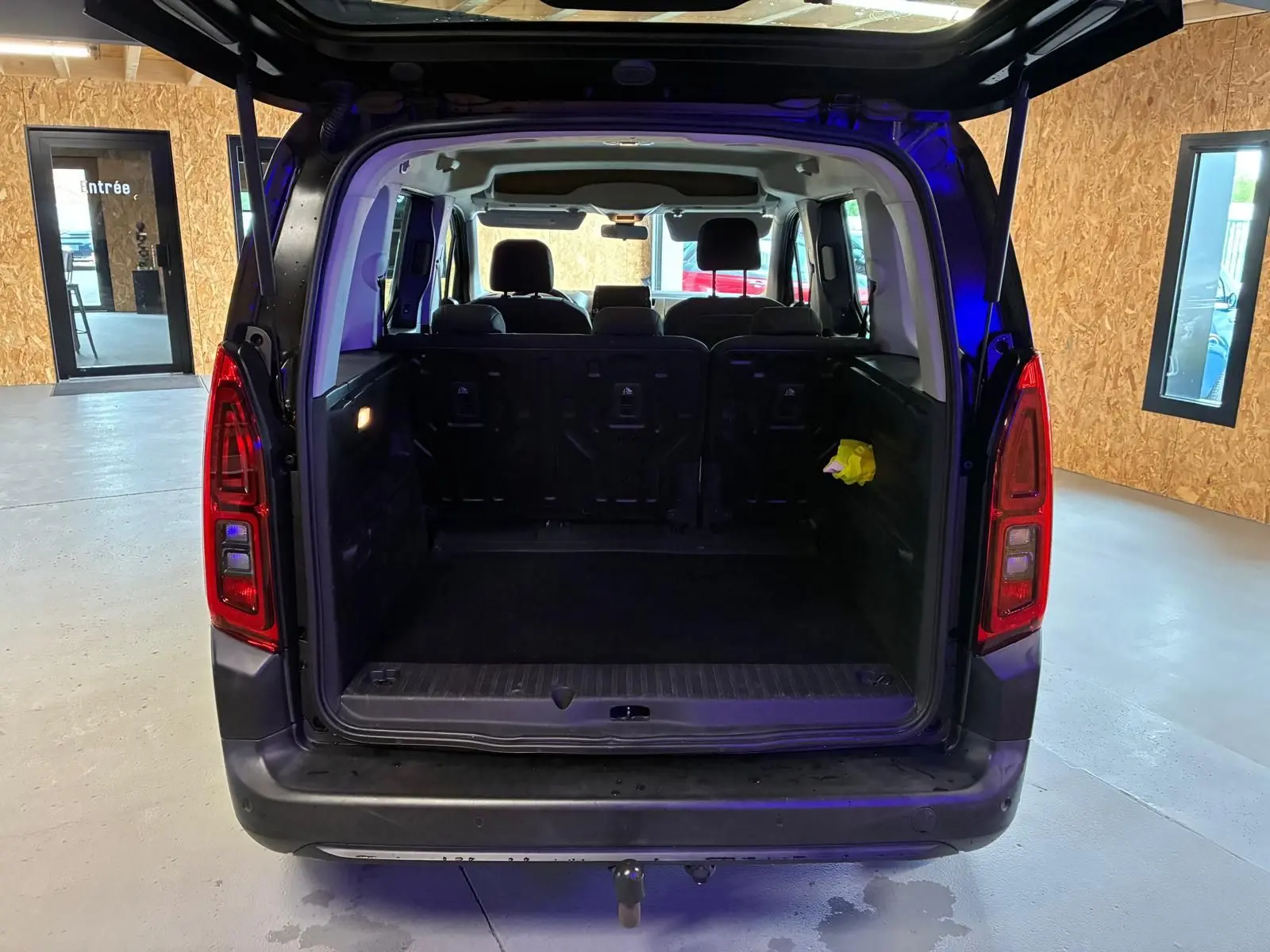 Vue arrière ouverte du Citroën Berlingo noir 2020 montrant le grand coffre vide et les sièges arrière en tissu noir.