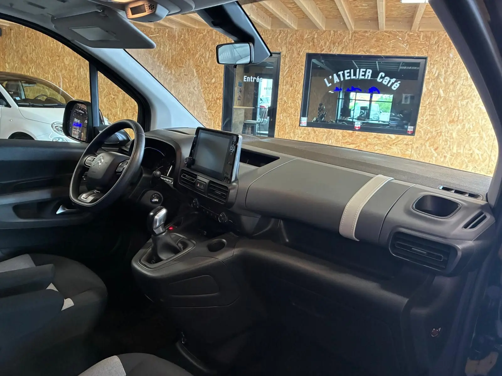 Vue intérieure côté conducteur du Citroën Berlingo noir 2020, avec tableau de bord moderne et écran tactile central.