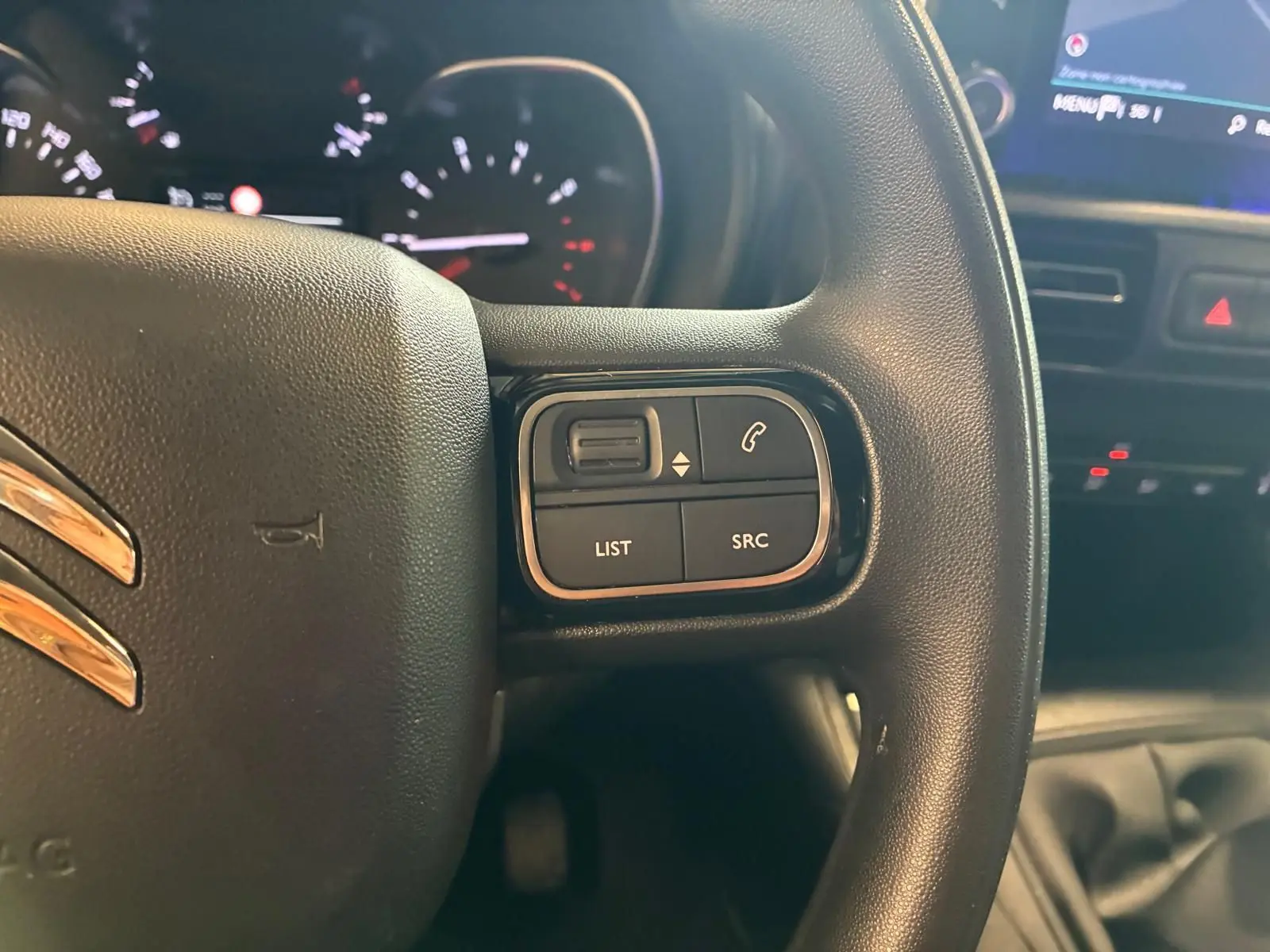 Gros plan sur le volant noir du Citroën Berlingo 2020, avec commandes audio et téléphone intégrées à droite.