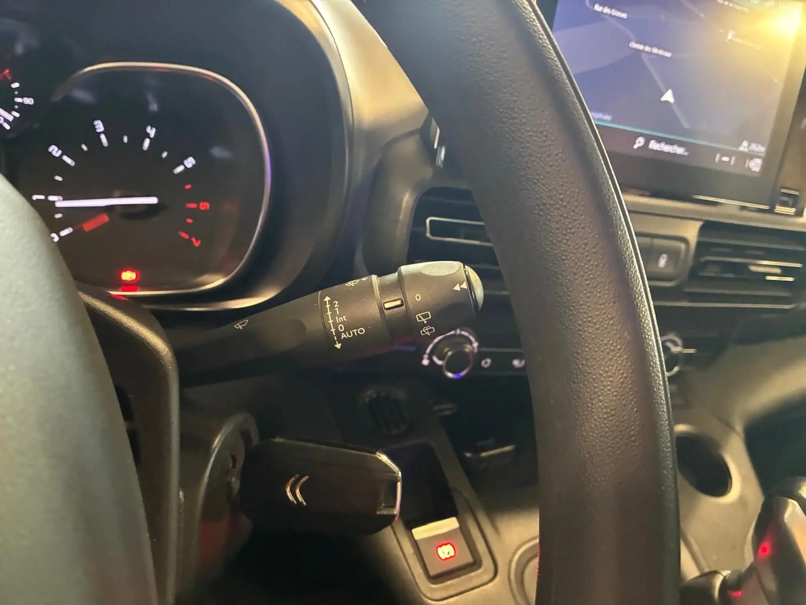 Vue rapprochée du volant côté gauche du Citroën Berlingo noir 2020, avec commandes au volant et écran GPS visible.