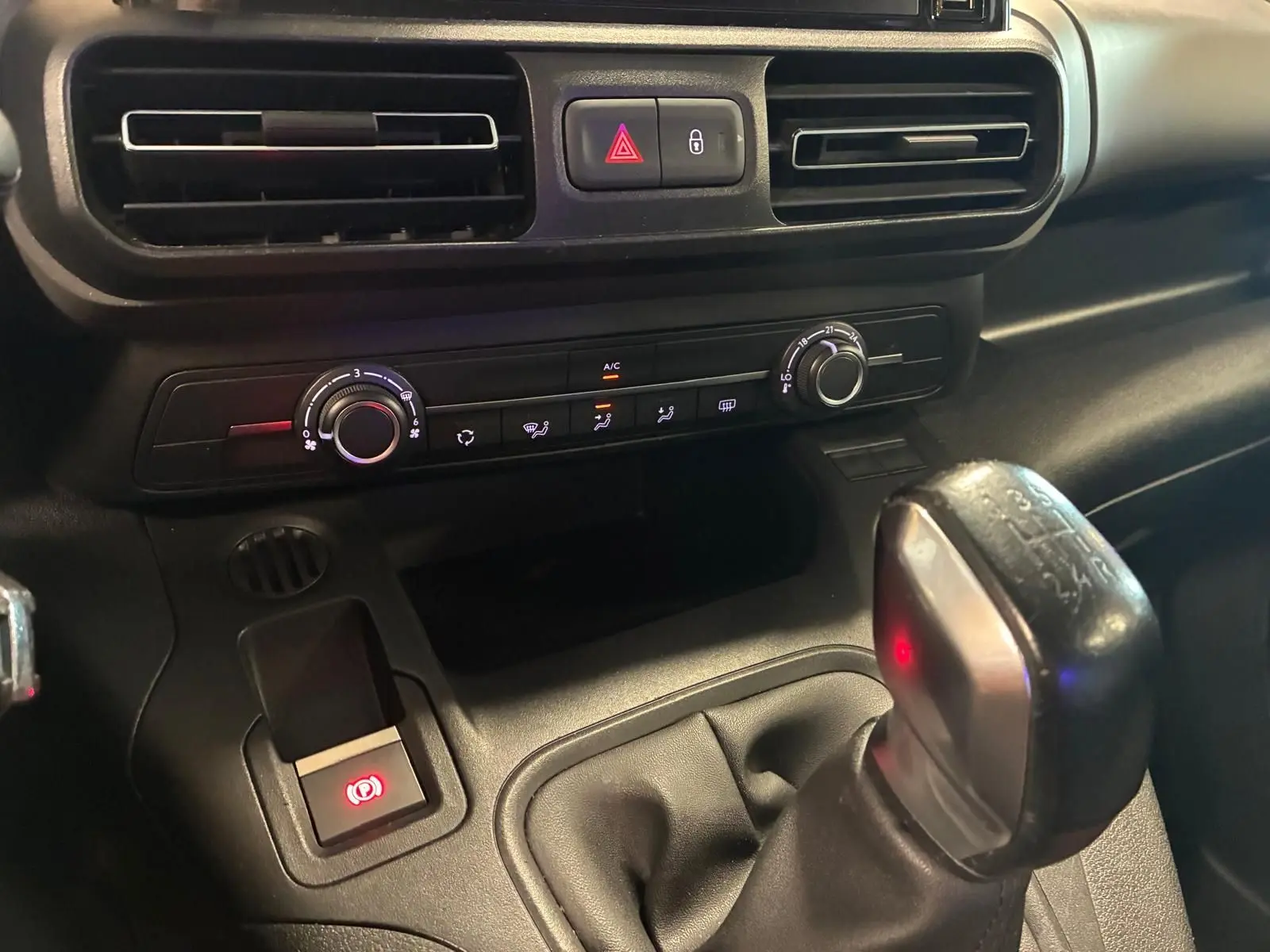 Vue rapprochée de la console centrale du Citroën Berlingo noir 2020, avec levier de vitesse manuel et commandes climatisation.