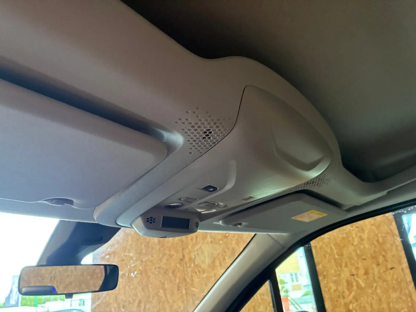 Vue intérieure du plafond avant du Citroën Berlingo noir 2020, montrant les commandes d'éclairage et le pare-soleil côté conducteur.
